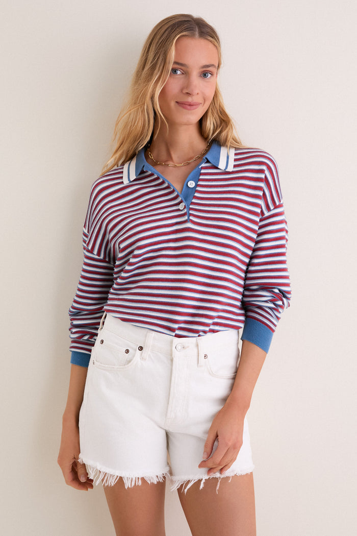 Young person models the All-Star Stripe Clark Sweater, a classic, effortless polo-style top with red, white, and blue stripes, paired with high-waisted white denim shorts.