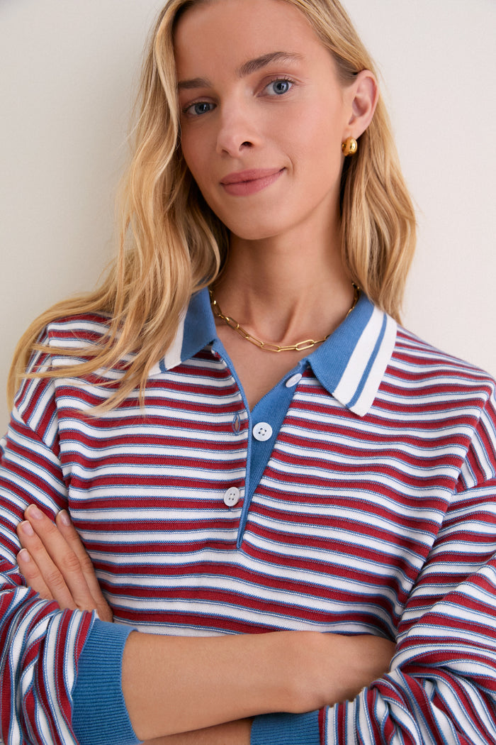 Young woman wearing the All-Star Stripe Clark Sweater, showcasing a classic, effortless style with its red, white, and blue stripes, embodying a fun, high-end look.