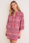 Woman wearing the classic Americana Batik Stripe Bondi Coverup, featuring effortless tassel neckties, three-quarter sleeves, and a fun, high-end floral-geometric stripe design.