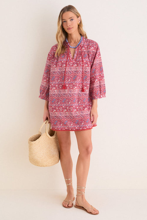 Woman in classic Americana Batik Stripe Bondi Coverup, featuring effortless floral print, tassel ties, and fringed hem. Styled with fun accessories for a high-end beach look.
