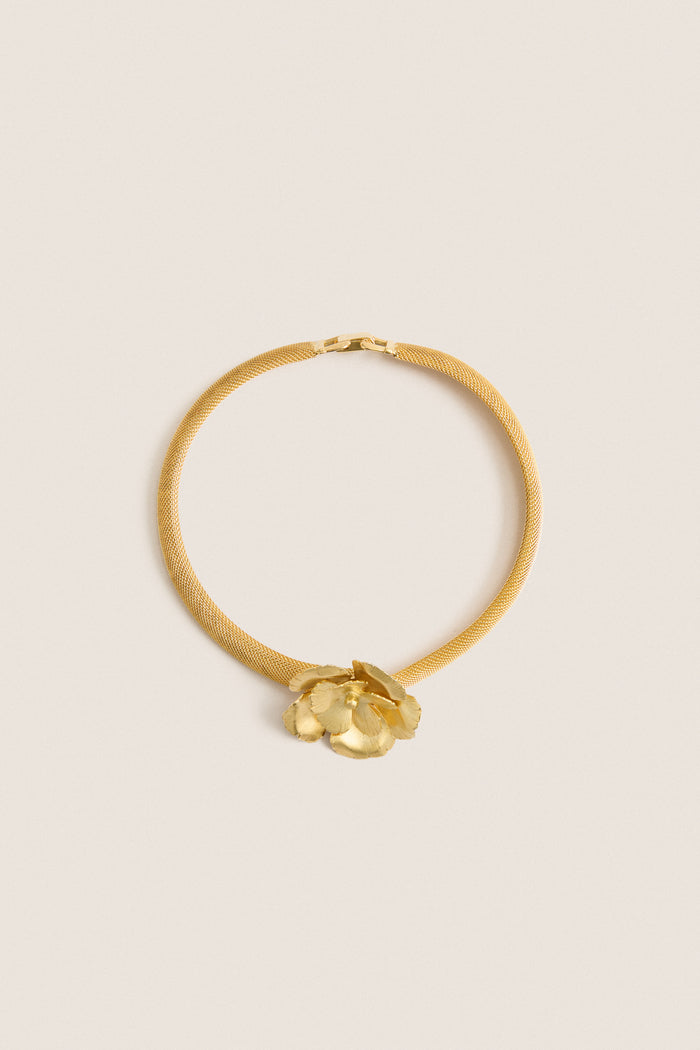 Antique Gold Eden Mesh Choker featuring a classic gold-tone mesh band with a sculpted flower centerpiece, offering an effortless, high-end touch for fun, confident styling.
