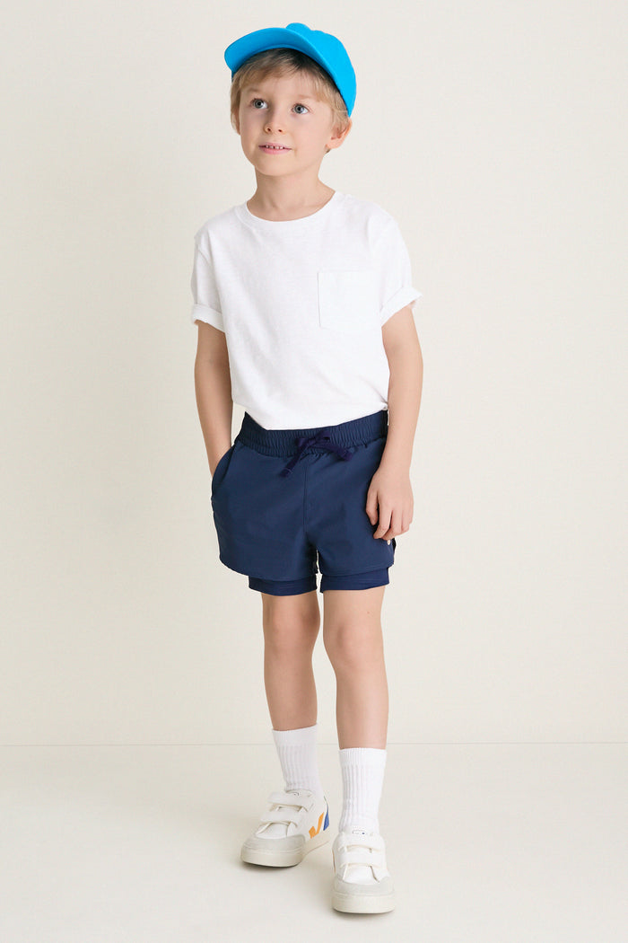 Young boy in classic, effortless Before Sunrise Blue Cardio Short, showcasing fun, high-end style with elastic waistband and pockets, embodying Tuckernuck's cool, ready-for-anything spirit.