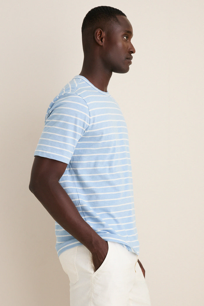 Young man in profile wearing the Bermuda Sail Stripe Sunwashed Tee, showcasing classic, effortless style with its slub jersey fabric and relaxed fit for a fun, high-end look.