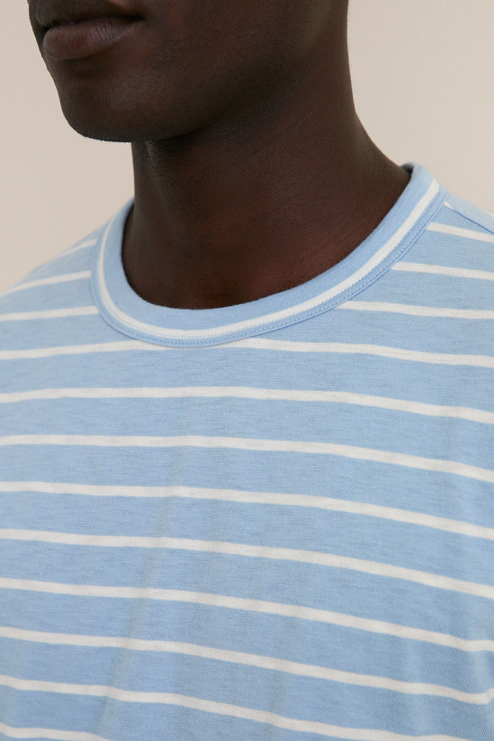 Close-up of a neck wearing the Bermuda Sail Stripe Sunwashed Tee, showcasing classic, effortless nautical style in a high-end, ultra-soft cotton fabric with thin stripes.