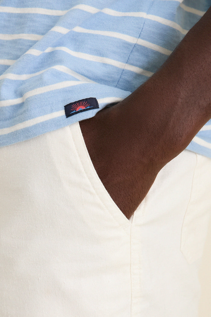 Close-up of a dark-skinned person wearing the Bermuda Sail Stripe Sunwashed Tee, showcasing its classic, effortless, nautical style with a relaxed fit and high-end slub jersey fabric.