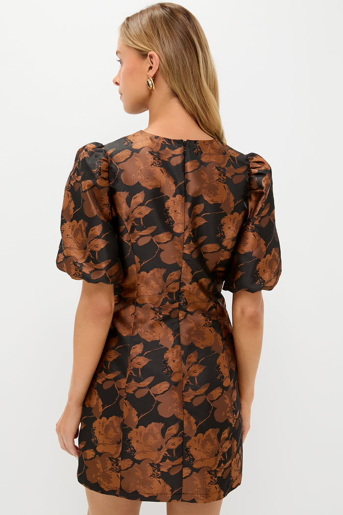 Back view of a woman in a classic Black & Copper Floral Jacquard Minetta Mini Dress with puffed sleeves, exuding effortless style and fun, high-end elegance.