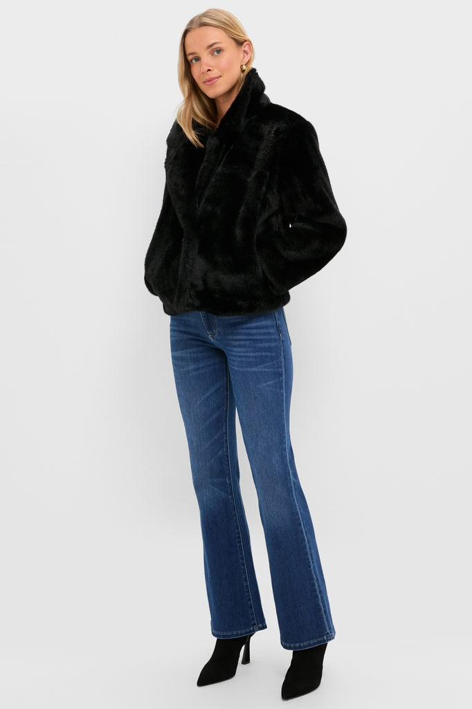 Model wearing the Black Faux Fur Taos Jacket, a classic and effortless piece paired with high-waisted flare jeans, embodying a high-end, fun style.