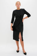 Black Jersey Knit Wilbanks Midi Dress featuring a classic twist detail at the waist, effortless three-quarter sleeves, and a fun leg slit, styled with a high-end black clutch.