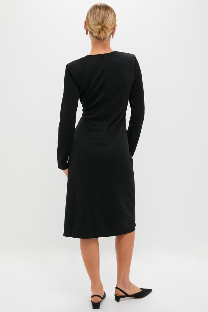 Back view of a model in the Black Jersey Knit Wilbanks Midi Dress, showcasing its classic, effortless style with a fitted silhouette, structured shoulder pads, and three-quarter sleeves.