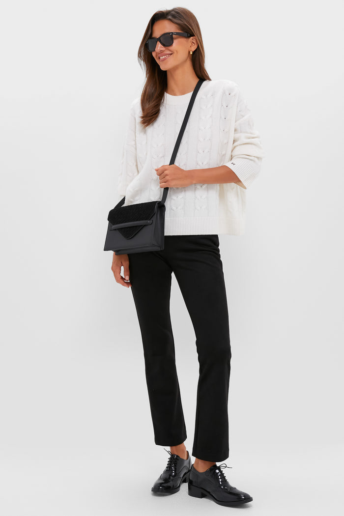 Woman wearing classic Black Leather Brogue Oxford Shoes with cut-out detailing and a block heel, styled with trousers, embodying an effortless, high-end, fun look.