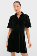 Model wears the classic Black Velvet Mini Delaney Dress with a polo collar, flutter sleeves, and A-line skirt, embodying effortless, high-end style for fun, versatile occasions.