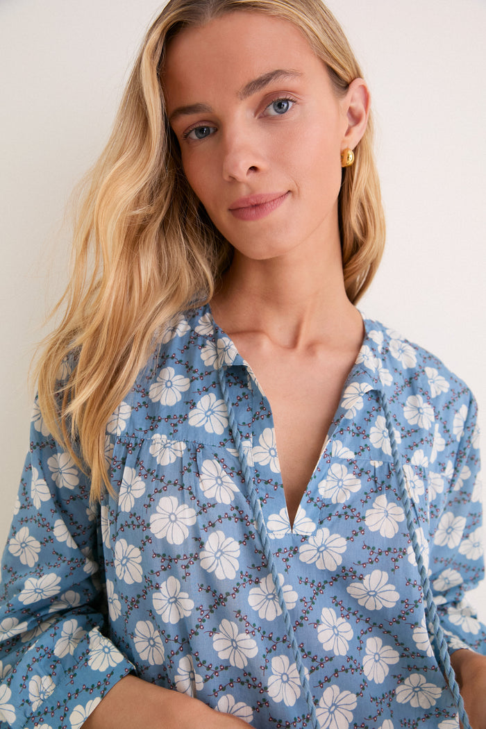 Effortlessly chic, the Bloom Lagoon Bondi Coverup features a sky-blue floral design, V-neck with braided tie, and a classic relaxed fit, exuding high-end boho style.