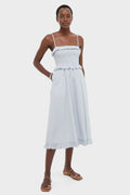 Effortlessly chic, the Blue and White Stripe Karine Midi Dress features a classic smocked bodice, adjustable straps, ruffle trim, and side pockets, embodying high-end, fun style.