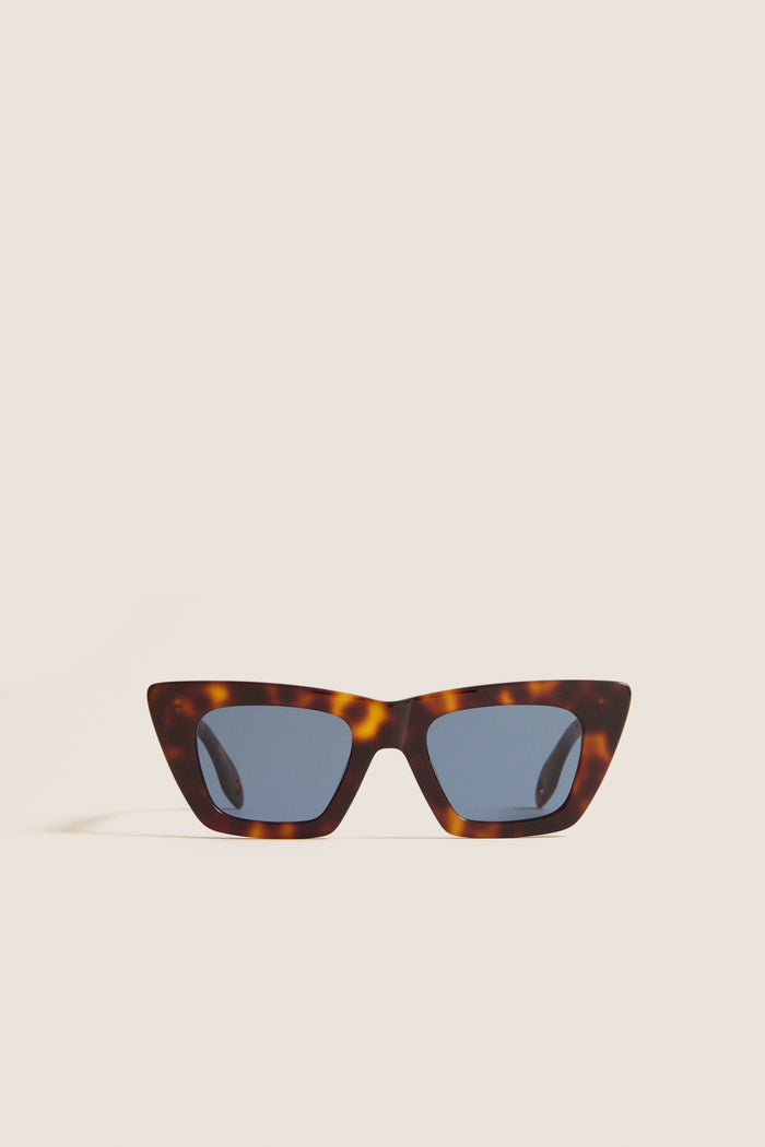 Brown Tortoise Dark Blue Lens Lori Sunglasses, featuring a classic cat-eye shape with a tortoiseshell frame, offer an effortless, high-end touch with a fun, modern twist.