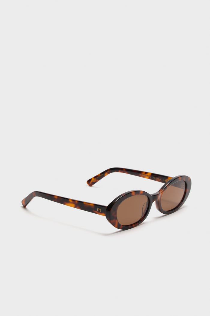 Brown Tortoise Lyric Leigh Sunglasses feature a classic oval design with tortoiseshell frames and matching lenses, embodying effortless, high-end style with a fun, bold edge.
