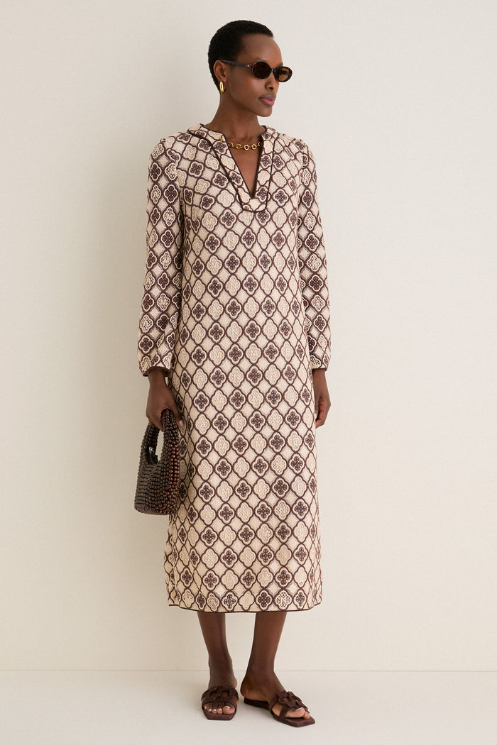 Model wears Brown Tortoise Lyric Leigh Sunglasses, embodying classic elegance with an effortless vibe, paired with a patterned dress, gold accessories, and a chic handbag.