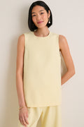 Woman wearing the classic Butter Maxime Top, an effortless sleeveless design with crewneck and side slits, paired with matching trousers, exuding fun and high-end elegance.