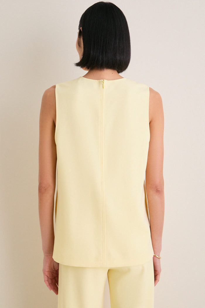 Model in classic, sleeveless Butter Maxime Top with center back zipper, showcasing effortless style. Perfectly paired with matching trousers for a fun, high-end look.