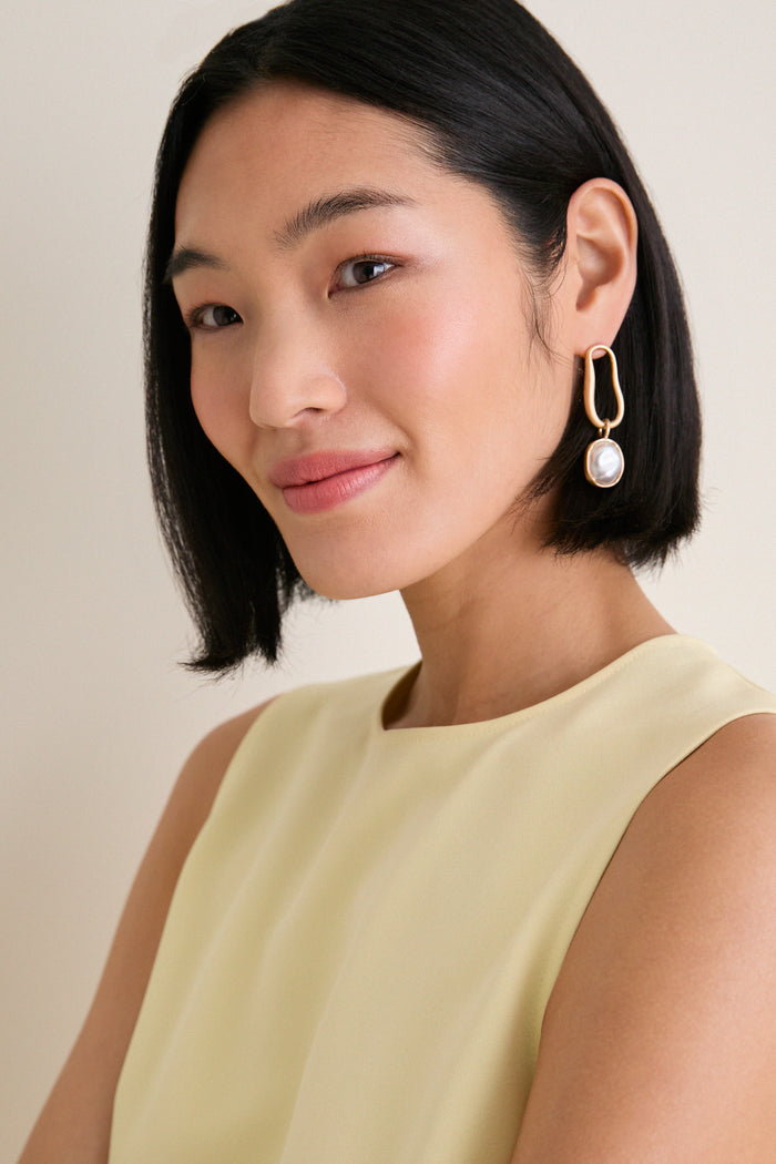 Young woman models the Butter Maxime Top, a classic, sleeveless design with a crew neckline. Effortless and high-end, it’s perfect for a fun, polished look.