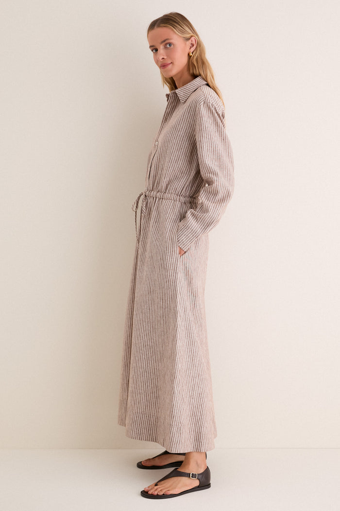 Cafe Stripe Linen Julien Shirt Dress: A classic, high-end shirt dress with effortless style, featuring tan-and-white stripes, drawstring waist, and side pockets, paired with fun, black thong sandals.