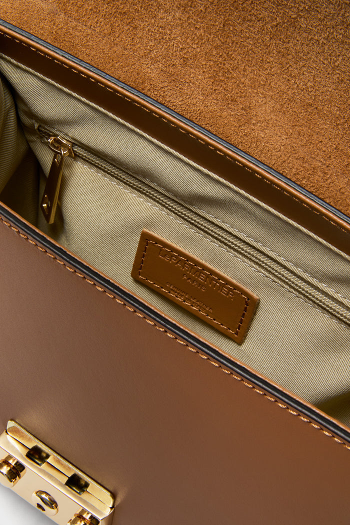 Caramel Peggy Top Handle Satchel Bag showcasing classic tan leather, gold hardware, suede lining, and practical compartments; an effortlessly high-end, fun accessory by Le Parmentier Paris.