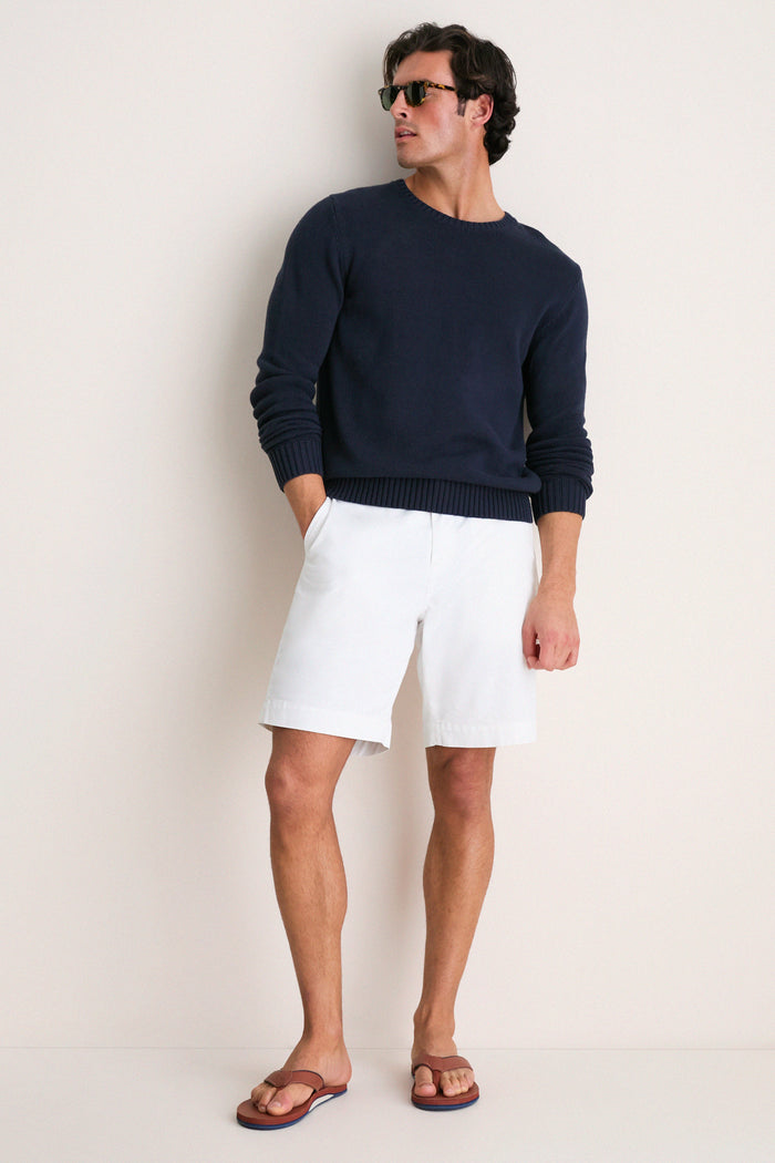 Model in navy sweater and white shorts wearing classic, high-end Cask Clipper Waterproof Leather Sandal, a fun and effortless choice for beach adventures.
