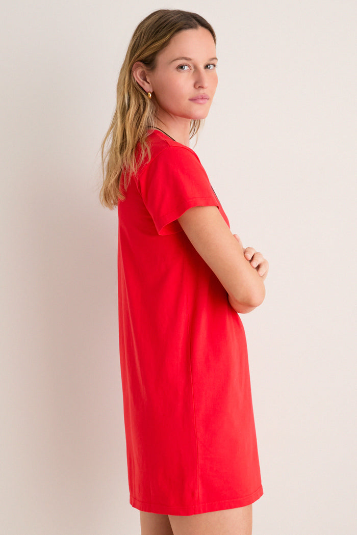 Young woman in profile wearing the classic Cerise Margo Mini Dress, featuring a boxy silhouette, crew neckline, and short sleeves, exuding effortless, high-end style.