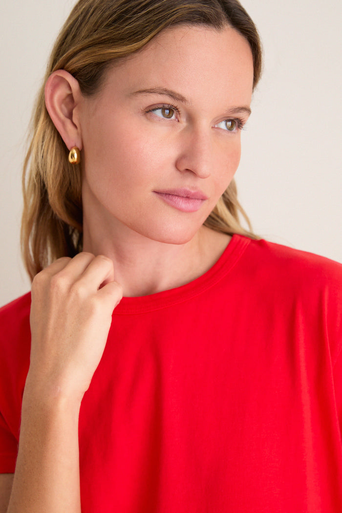 Young woman in a bright red Cerise Margo Mini Dress with a boxy silhouette and crew neckline, embodying classic and effortless high-end style.