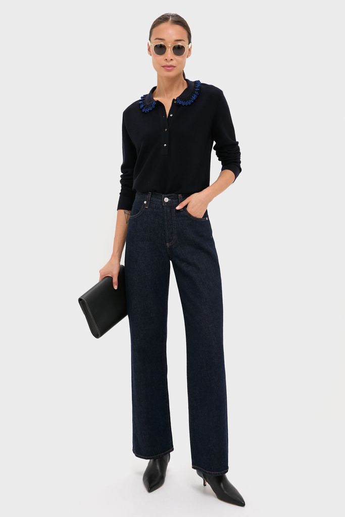 Woman in classic Champagne Leonard Sunglasses, exuding effortless style with a black top and jeans, embodying a fun, high-end fashion essence.