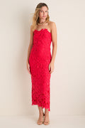 Woman models the Cherry Red Philomena Midi Dress, featuring a classic strapless design and raised floral-lace pattern, paired with gold accessories for an effortless, high-end look.