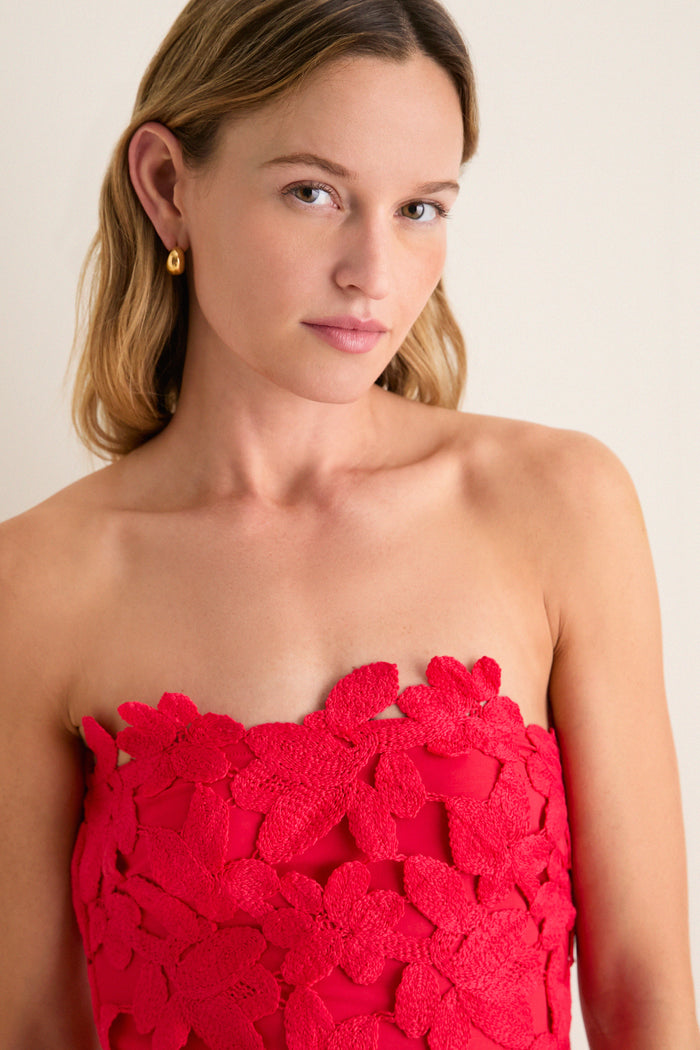Young woman in a classic, strapless Cherry Red Philomena Midi Dress with floral lace, exuding effortless, high-end elegance. Perfect for a fun, confident look.