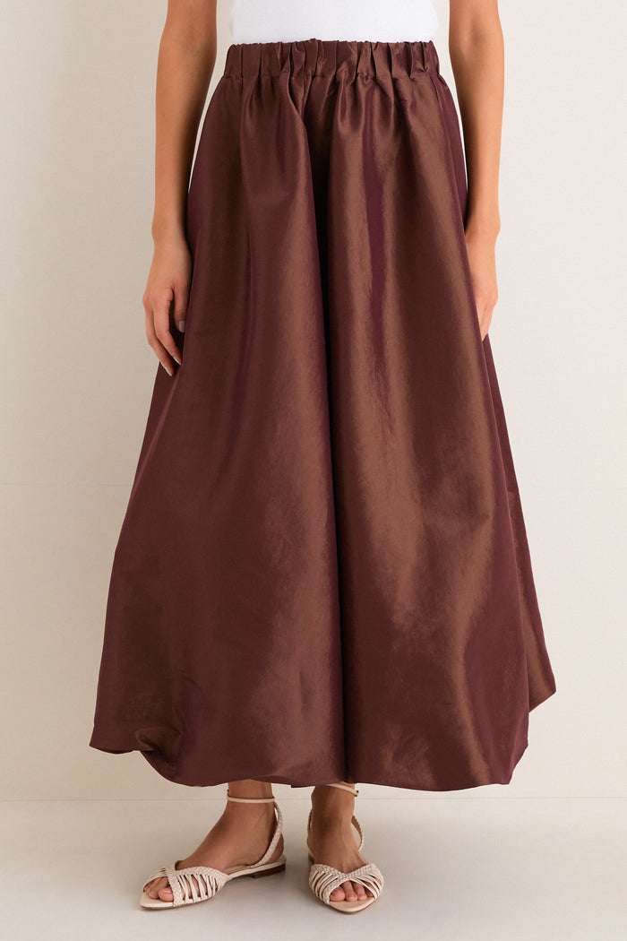 Classic and effortless, the Chestnut Taffeta Cynthia Bubble Skirt features a fun, high-end bubble hem and elastic waistband, styled with woven sandals for a chic look.