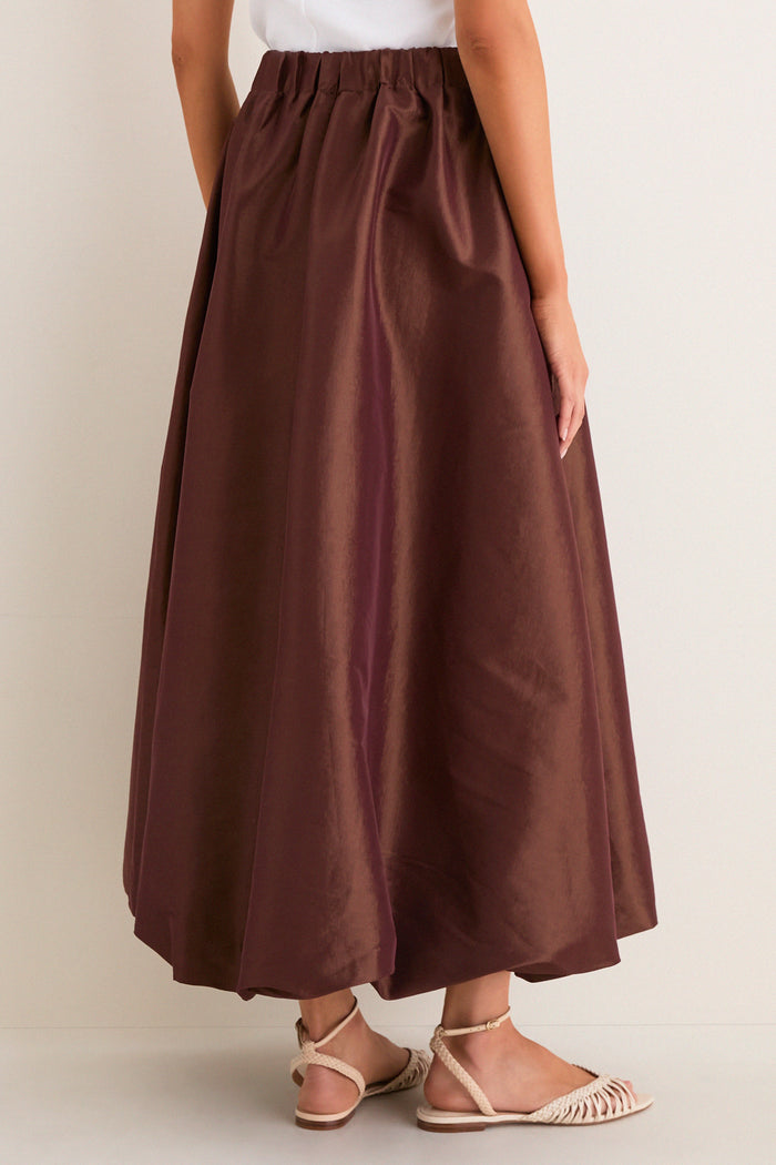 Effortless classic style with the Chestnut Taffeta Cynthia Bubble Skirt, featuring a bubble hem and elastic waistband, paired with woven sandals for a high-end, fun look.