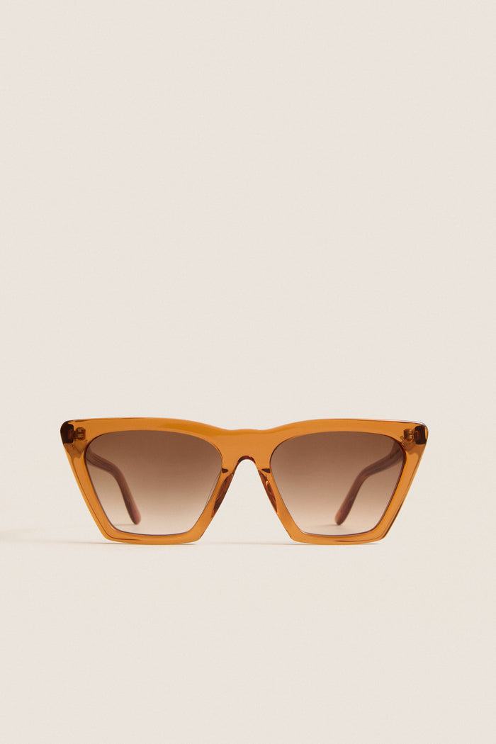 Cider Lisbon Sunglasses feature a classic, effortless cat-eye shape with translucent amber-orange frames, ideal for fun, high-end adventures. Perfect for confident, everyday style.