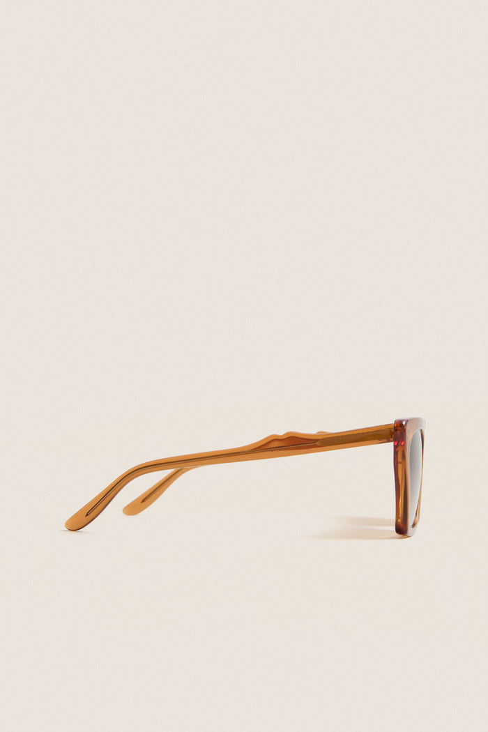 Cider Lisbon Sunglasses in translucent amber, featuring a classic cat-eye silhouette and three-barrel hinge, embodying effortless, high-end style for fun, everyday wear.
