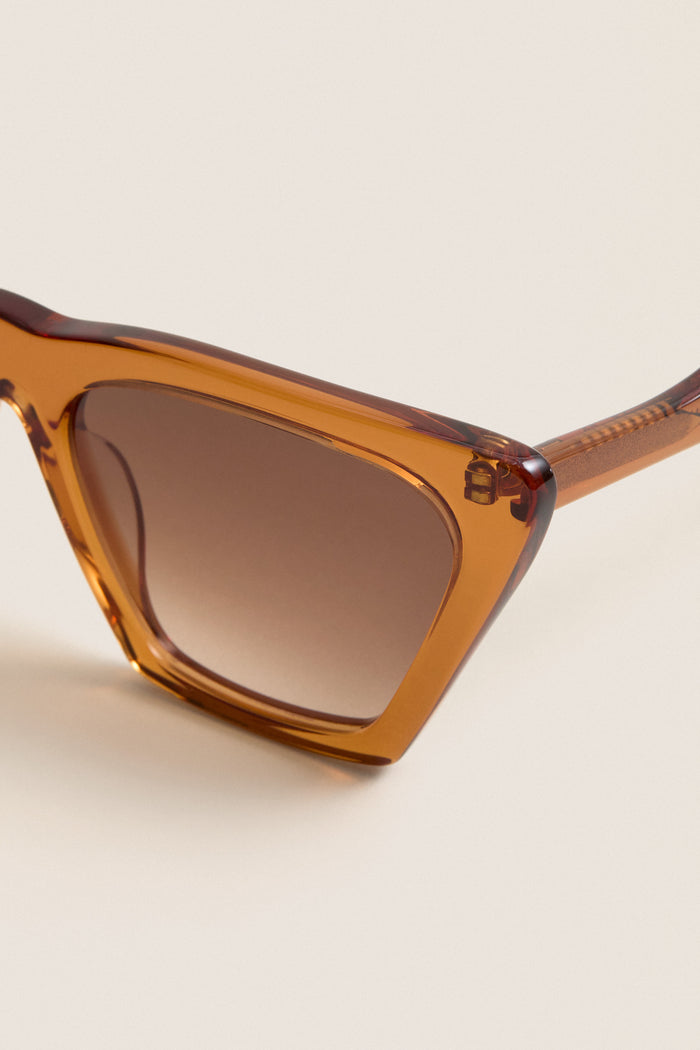 Cider Lisbon Sunglasses feature a classic cat-eye shape with translucent amber-brown frames and gradient lenses, offering an effortless, fun, and high-end accessory for everyday wear.