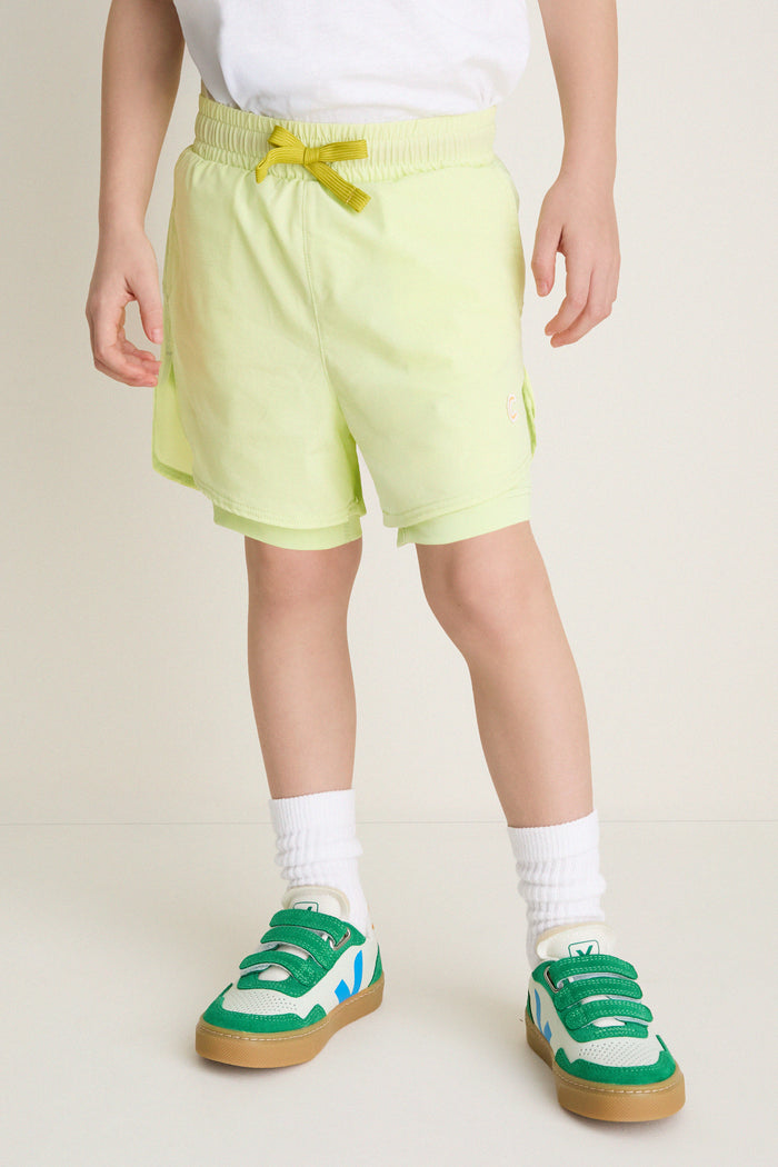 Child mannequin in Citron Zest Cardio Short, blending classic athletic style with effortless fun. Paired with white socks and sneakers, perfect for active, high-end comfort.