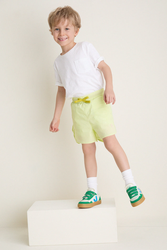 Young boy in Citron Zest Cardio Short with elastic waistband, effortlessly stepping forward in classic, high-end style, showcasing a fun, nostalgic athletic look.