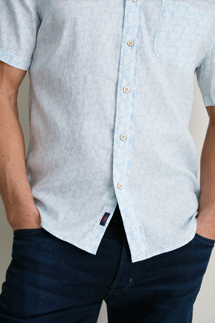 Person wearing the Clear Sky Leaf Breeze Shirt, a classic, effortless, and fun design with a subtle leaf pattern, paired with dark jeans for a high-end summer look.