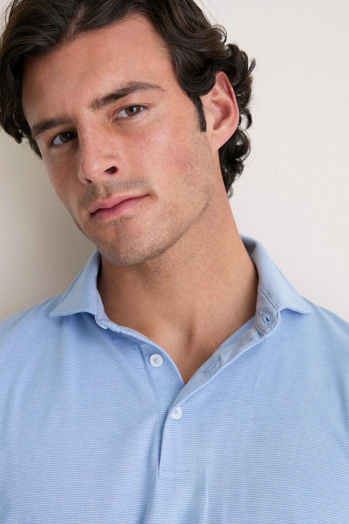 Young man in a classic, effortless Cloudy Blue Ryles Crown Flex Cotton Polo, featuring a cutaway collar and streamlined fit, exuding high-end casual elegance.