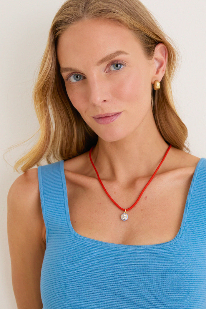 Woman wearing classic Coral Red Necklace Cord with Blue Bezel Charm, exuding an effortless, high-end style. Fun and versatile accessory suits any outfit and occasion.