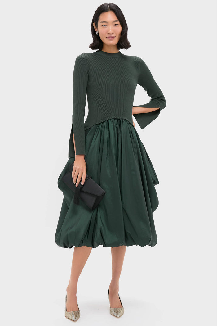 Woman exudes effortless elegance with Crystal Violet Stud Earrings, a classic glam touch. Paired with a dark green ensemble and metallic pumps, she embodies high-end style.