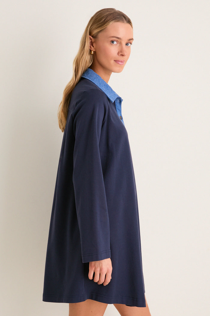 Young woman modeling the Denim Collar Carolyn Swing Mini Dress, showcasing its classic and effortless style. The dress exudes fun and high-end appeal with its distinctive design.