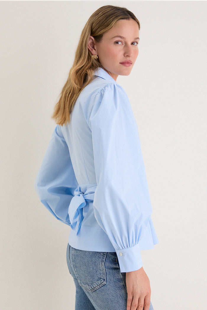 French Blue Tie Front Bow Bea Blouse exudes classic elegance with its effortless wrap design, voluminous sleeves, and chic bow detail, perfect for a high-end, fun style.