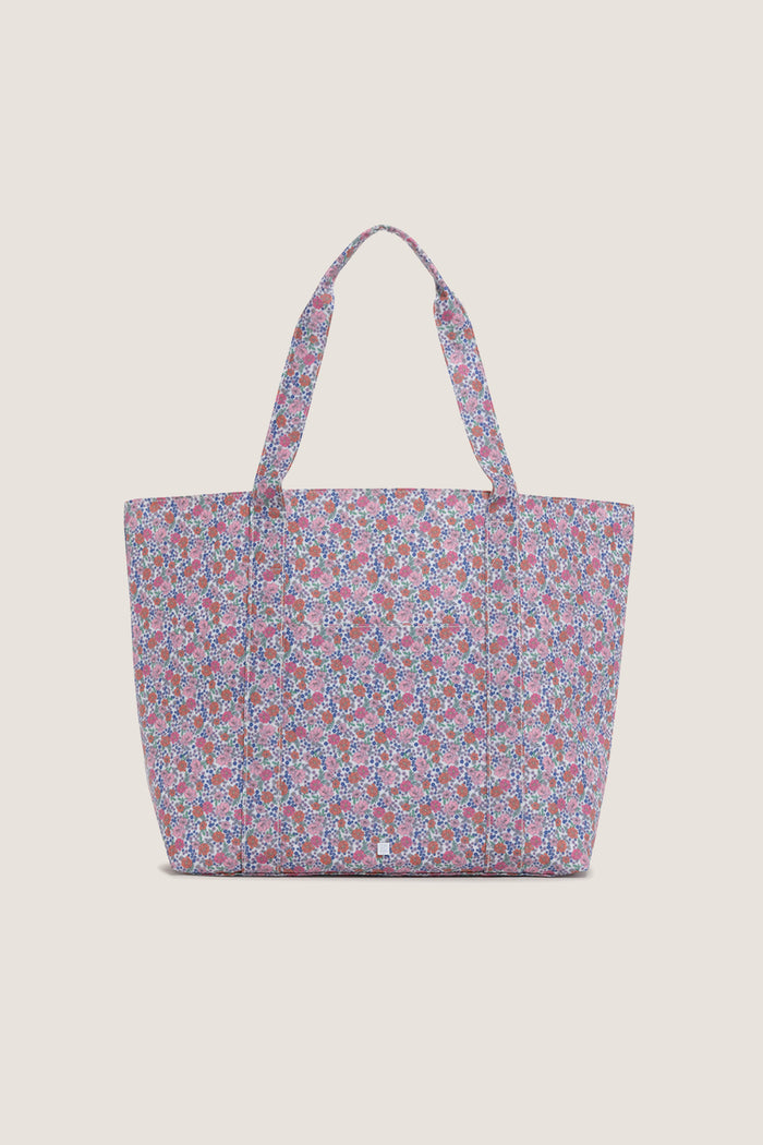 Garden Floral Jumbo Tote with a ditsy floral pattern, featuring an exterior pocket and sturdy handles, embodies effortless, classic style perfect for a fun, high-end shopping experience.