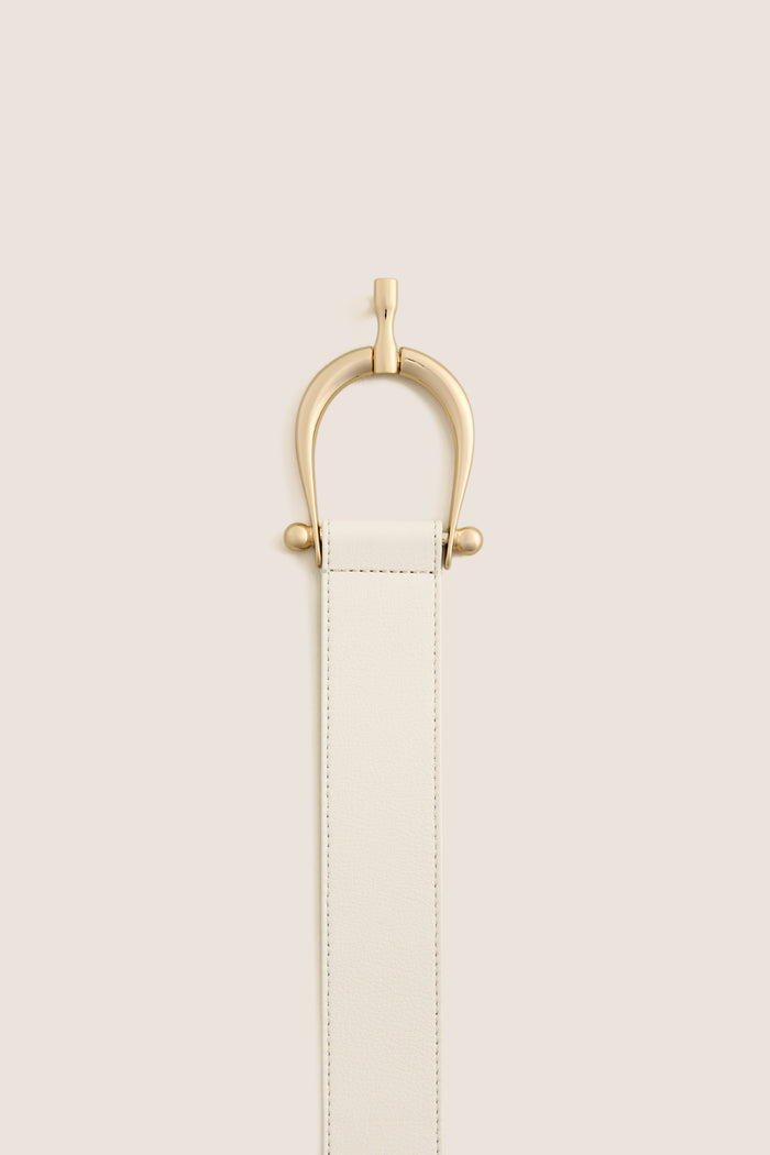 Gesso Grant Belt featuring a classic off-white leather strap with an elegant gold-tone clasp, exudes effortless high-end style, ideal for versatile, fun fashion statements.