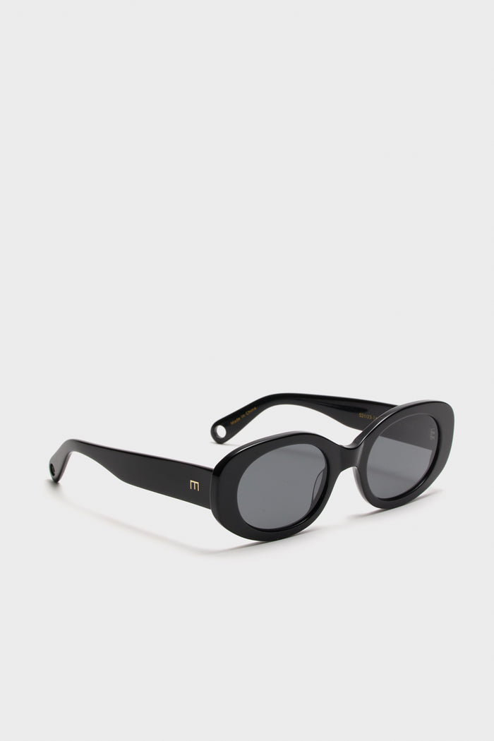 Gloss Black Lyna Sunglasses feature classic oval lenses and glossy acetate frames with a subtle gold E logo, embodying effortless high-end style and fun sophistication.