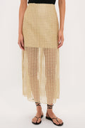 Woman's lower half wearing a classic Gold Metallic Star Lace Eve Skirt, effortlessly styled with a black top and sandals, showcasing high-end, airy elegance with a fun, sheer finish.
