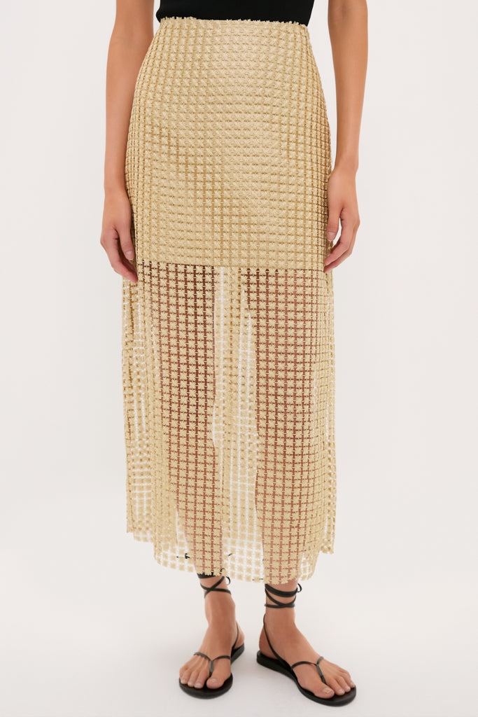 Woman's lower half wearing a classic Gold Metallic Star Lace Eve Skirt, effortlessly styled with a black top and sandals, showcasing high-end, airy elegance with a fun, sheer finish.