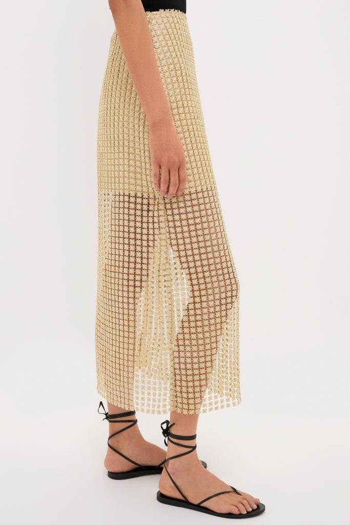 Woman wearing the Gold Metallic Star Lace Eve Skirt, featuring a classic, effortless style with a side slit, paired with fun, high-end black strappy sandals.